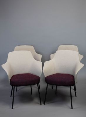 deux chaises blanches aux coussins violets et aux pieds noirs, adossées à un mur gris
