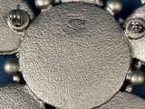 a silver brooch that is on a blue surface