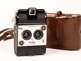 a brown bag and a brown camera on a white surface