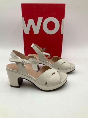 une paire de chaussures blanches pour femme, avec une boîte rouge en arrière-plan