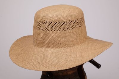 Le chapeau est en paille et présente un petit trou dans le bord.