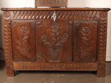 a wooden chest with a plant on top of it