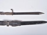 two different types of knives on a white surface