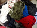 a suitcase full of clothes and clothes sitting on the floor