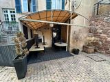 a patio with a table and benches under a awning