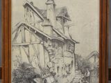 un vieux dessin représentant une maison, encadré et posé sur une étagère