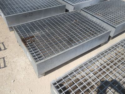 Plusieurs grilles en acier sont empilées les unes sur les autres au sol