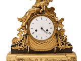 une horloge en or surmontée d'une statue
