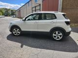 the white volkswagen suv is parked in front of a building
