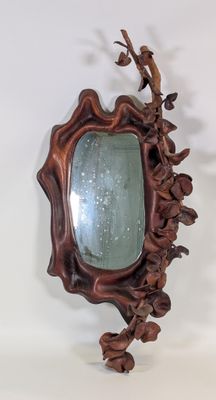 un miroir accroché au mur avec un oiseau dessus