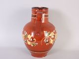 a red vase with gold and green designs on it