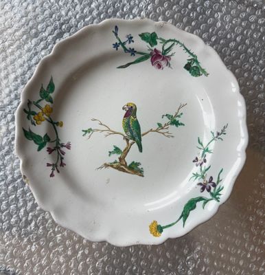 une assiette avec un oiseau posée sur une table