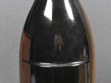 a black bottle with a red lid sitting on a table