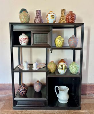 many different vases on a shelf in a room