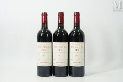 trois bouteilles de vin rouge sont alignées sur une surface blanche