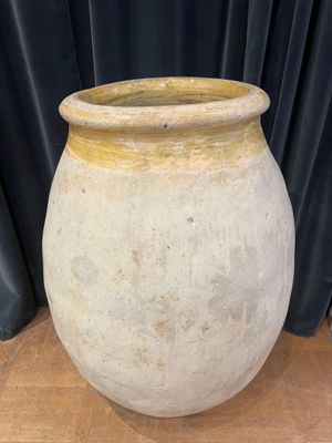 a large white vase sitting on a wooden table