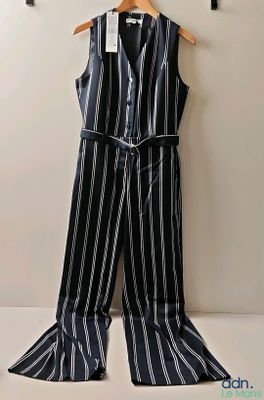 a black and white striped jumpsuit hanging on a hanger