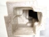 a white statue of a man sitting in a chair