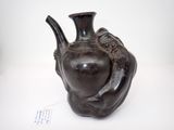 un vase noir orné d'un oiseau, posé sur une table
