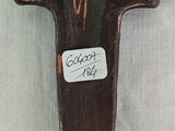 wooden cross with a sticker on it sitting on a white surface