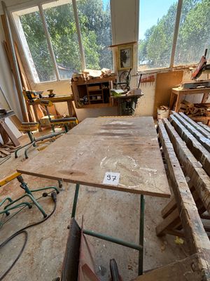 une table au milieu d'une pièce, sur laquelle sont posés de nombreux morceaux de bois