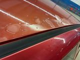 a close up of a red car with water on it