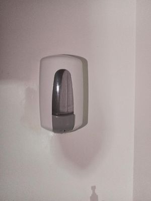 des toilettes et un distributeur de papier dans une salle de bains