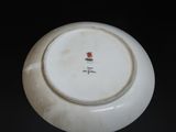 a white plate with a red flower on it