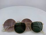 three pairs of sunglasses sitting on top of a white table