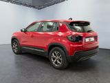 the rear end of a red car in a showroom