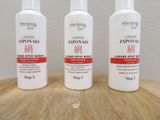three bottles of lotion sitting on a wooden table