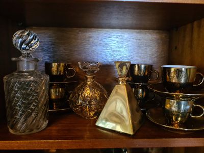une étagère sur laquelle sont disposés de nombreux objets en verre et en argent