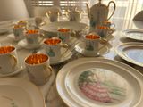 many cups and saucers sitting on a table