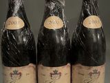 three bottles of wine wrapped in plastic sitting on top of a counter