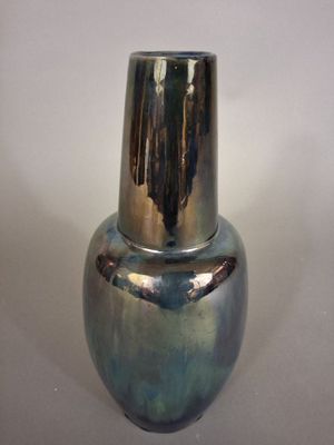 un vase en argent posé sur une table, sur fond blanc