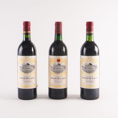 trois bouteilles de vin sont alignées sur une surface blanche