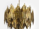 un grand lustre en laiton muni d'une longue chaîne suspendue au plafond