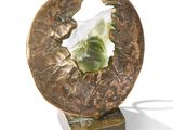 a sculpture of a leaf and a piece of paper on a stand