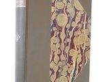 an old book with a gold and blue cover on a white background