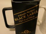 a black and gold label on a black and white pitcher
