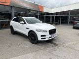 a white jaguar suv parked in front of a building