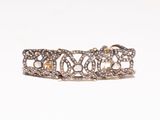 a close up of a gold and diamond bracelet on a white background