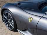 the rear end of a silver sports car parked on the side of the road