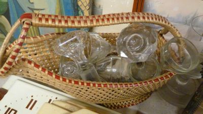 un panier en osier rempli de verres vides posé sur une table