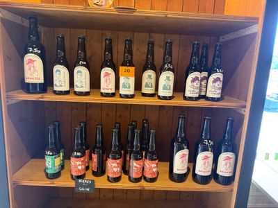 de nombreuses bouteilles de bière posées sur une étagère dans un magasin