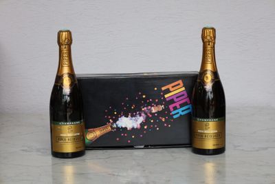 two bottles of champagne sitting next to each other on a table