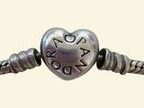 a close up of a bracelet with a heart on it