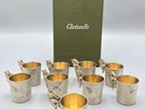 a set of six silver cups with gold rims and a green box