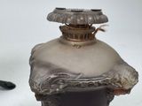 a silver vase with a black handle on a white table