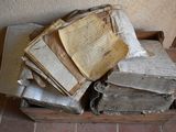 pile de vieux livres posés sur une boîte en bois sur un sol carrelé
